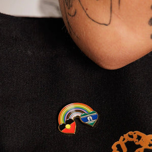 Pin with rainbow design on a black shirt