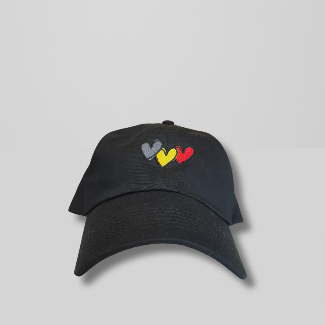 Black cap with colorful heart designs on a gray background